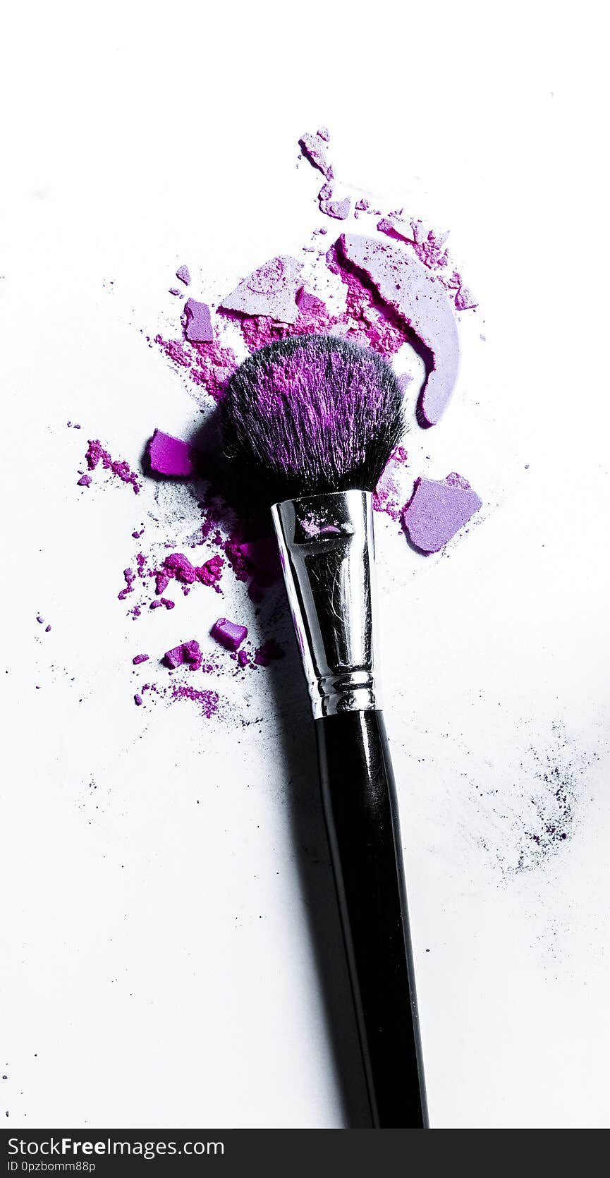 Brush with crushed eyeshadow and powder close-up isolated on white background