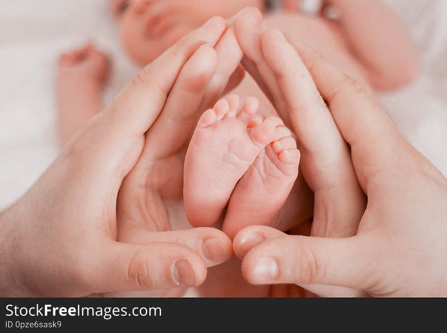 Pregnancy, maternity, preparation and expectation motherhood, giving birth concept. Newborn baby feet in hands of parents