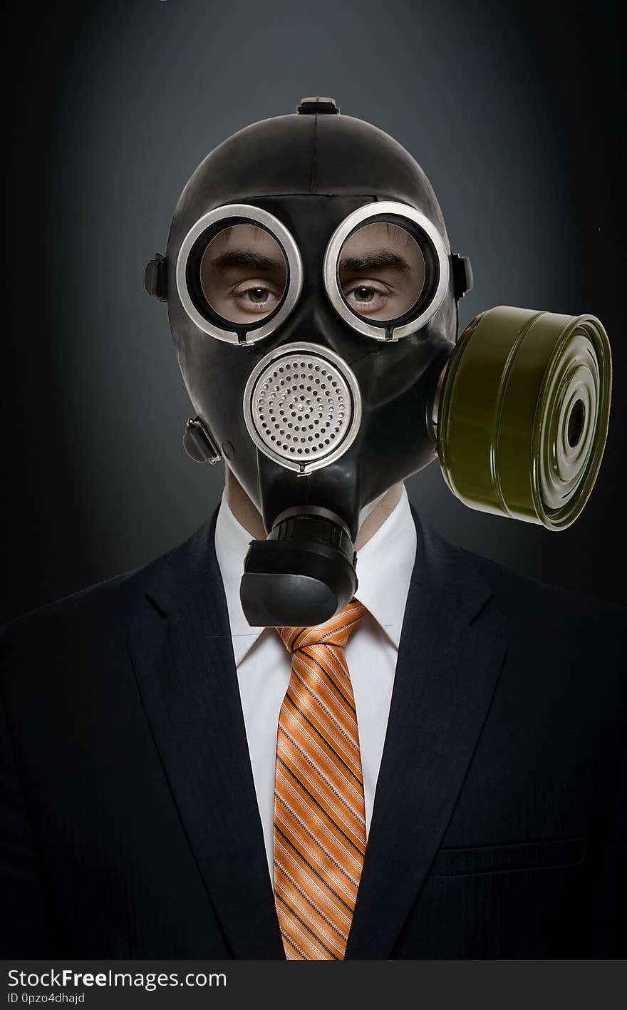 Businessman in black costume and gas mask; concept adioactive or chemical pollution. Businessman in black costume and gas mask; concept adioactive or chemical pollution