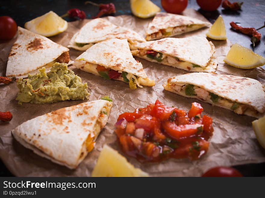 Quesadilla, mexican  tortilla wraps filled with cheese, meat and vegetables, cut in triangles. Quesadilla, mexican  tortilla wraps filled with cheese, meat and vegetables, cut in triangles