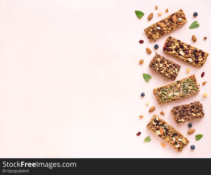 Granola bars assortment on white pink background, copy space. Homemade healthy snack - granola superfood bars