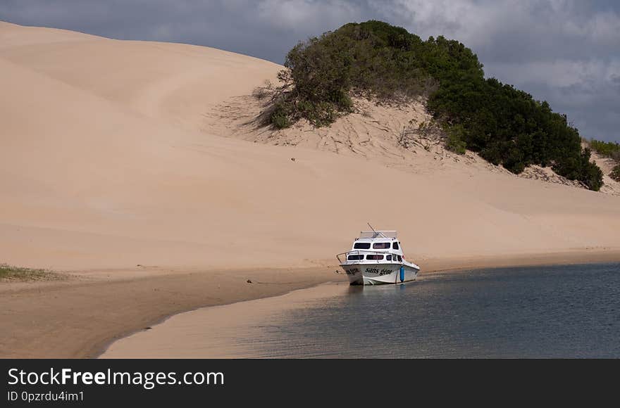 Boat moored at the Alexandria coastal dune fields near Addo / Colchester on the Sunshine Coast in South Africa. The dunes were photographed from the Sundays River on a clear summer`s day.