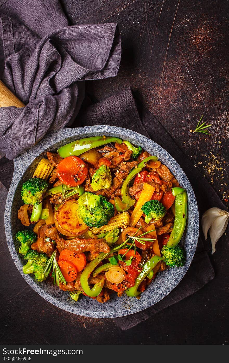 Fried beef stroganoff with potatoes and vegetables in a pan, top view