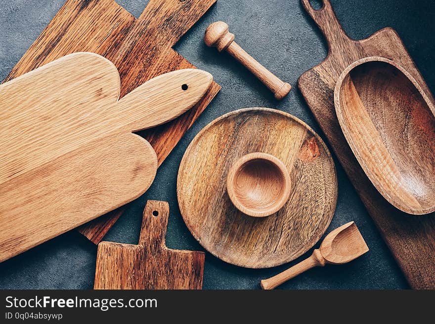 Set of wooden kitchen utensils, cutting boards, bowl, plate, mortar and pestle, scoop. Flat lay, top view