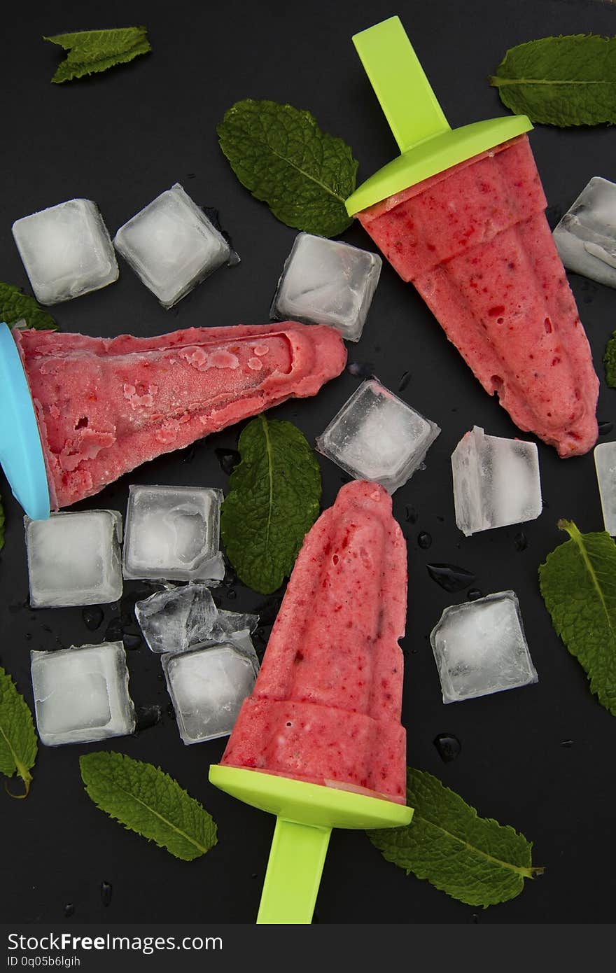 Summer icecream. Homemade berry popsicles on a rustic wood background. Fresh strawberry lolly icecream - greate treat for kids