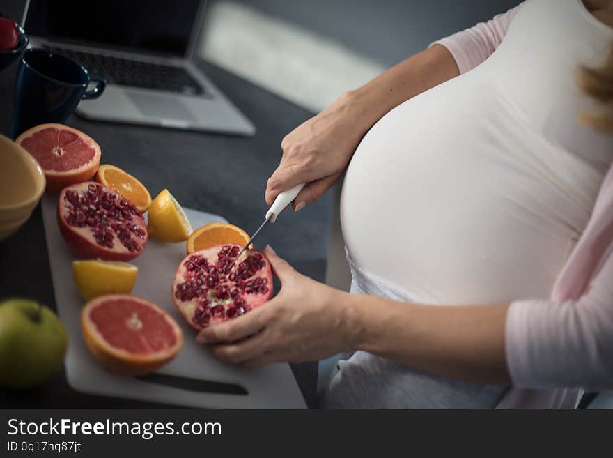 Only healthy mea. Pregnant woman in kitchen. Close up. Focus on hands