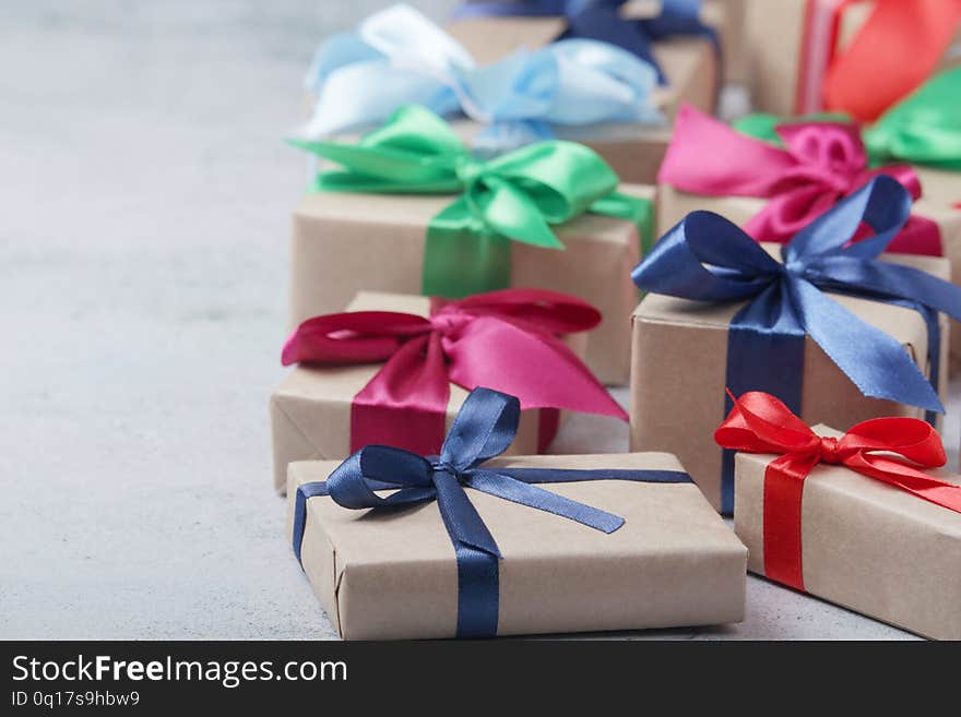 Boxes with presents and gifts wrapped with craft paper and colorful satin ribbons. Boxes with presents and gifts wrapped with craft paper and colorful satin ribbons