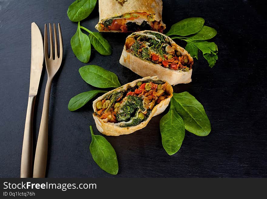 Vegetable savory strudel, with tomatoes and mushrooms on black background. Vegetable savory strudel, with tomatoes and mushrooms on black background