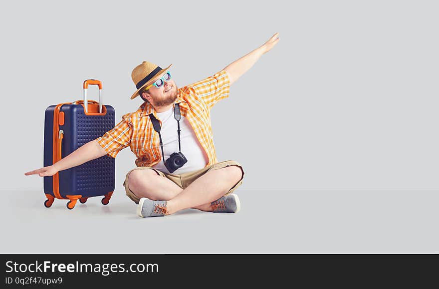 Fat funny man with a suitcase raised his hands up the airplane symbol.