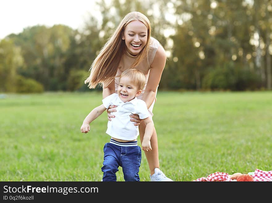 Mother with a child plays in the park on the grass. Mother with a child plays in the park on the grass.