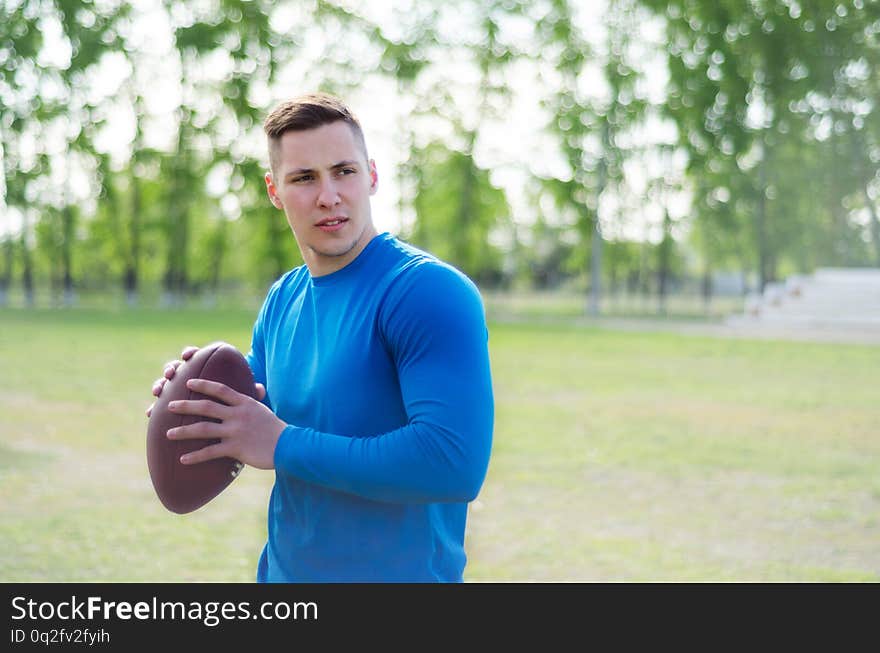 Portrait of a young american football player with a ball in training