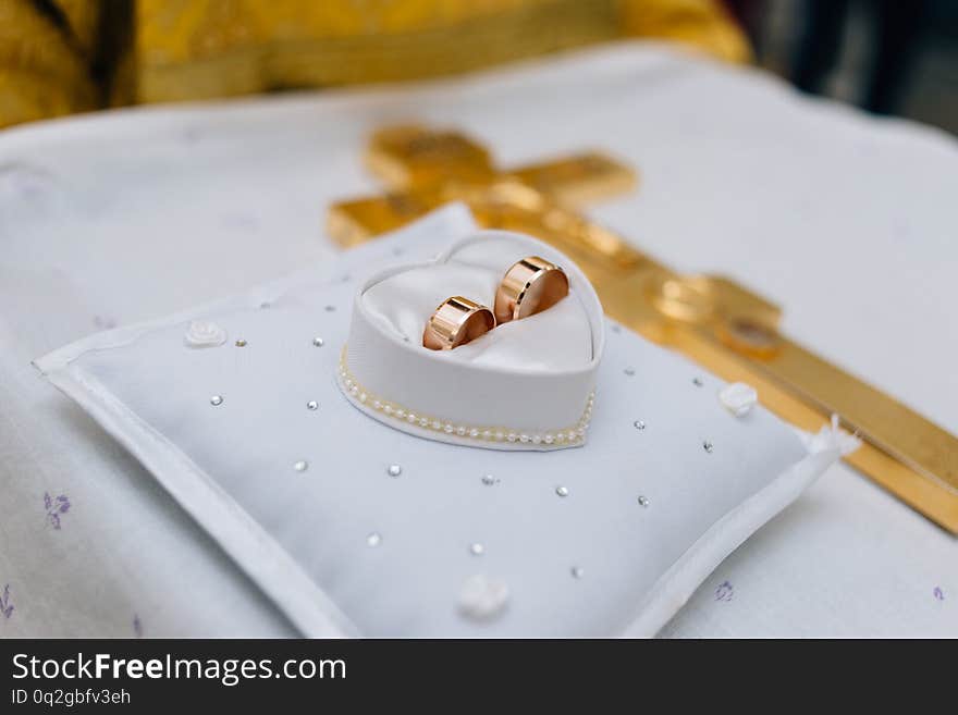 Wedding rings lie on the pillow next to each other