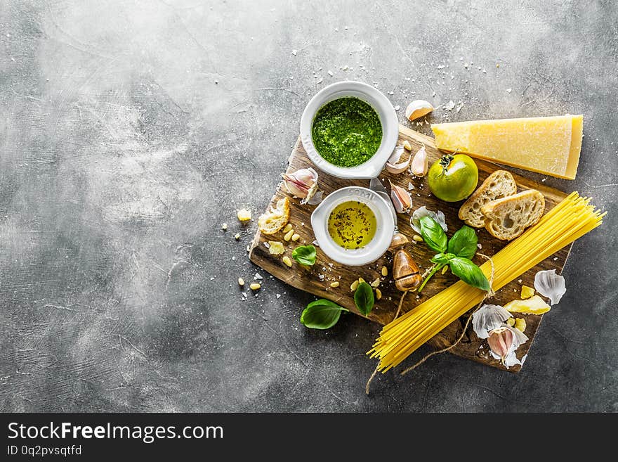 Italian food background. Ingredients for pesto, spaghetti and chiabatta bread on grey concrete background. View from above with Copy Space. Italian cuisine concept. Italian food background. Ingredients for pesto, spaghetti and chiabatta bread on grey concrete background. View from above with Copy Space. Italian cuisine concept