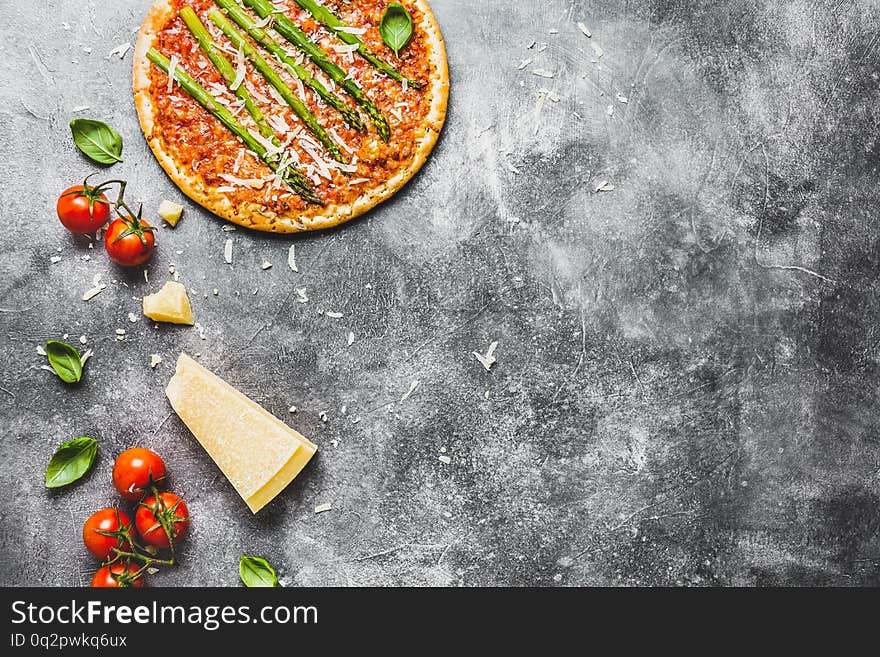 Tasty italian pizza with tomato sauce, cheese and asparagus. Grey background. Copy Space, Horizontal. Tasty italian pizza with tomato sauce, cheese and asparagus. Grey background. Copy Space, Horizontal