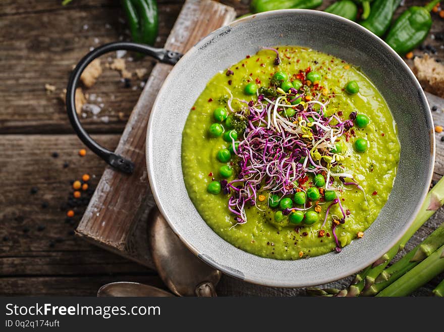 Healthy green pea soup served in bowl