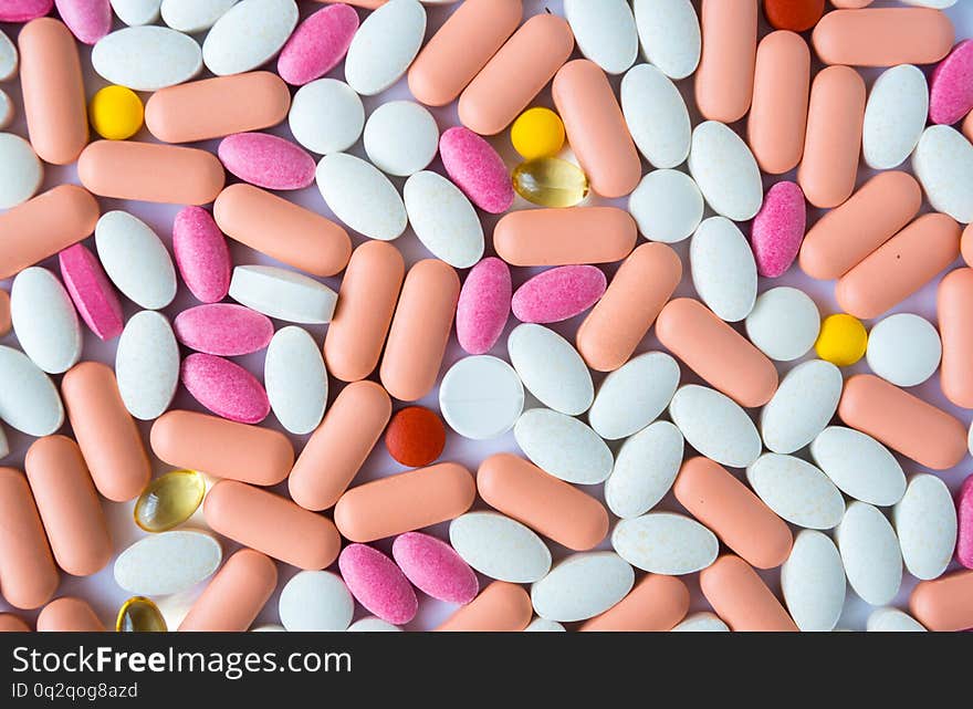 Many Pills And Drugs In Bright Colors On White Background