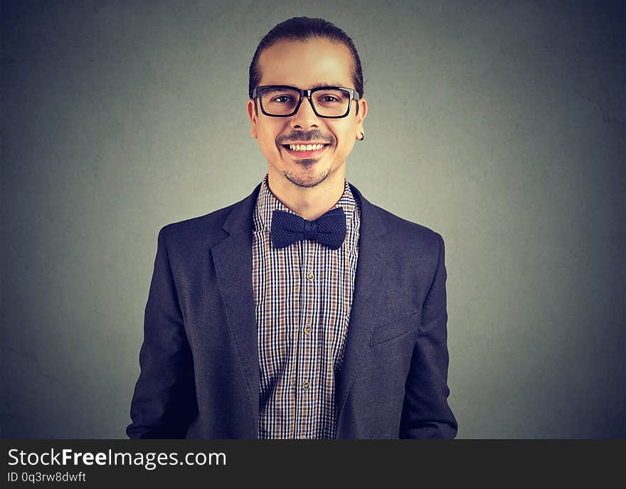 Portrait of a confident smiling independent business man on gray wall background