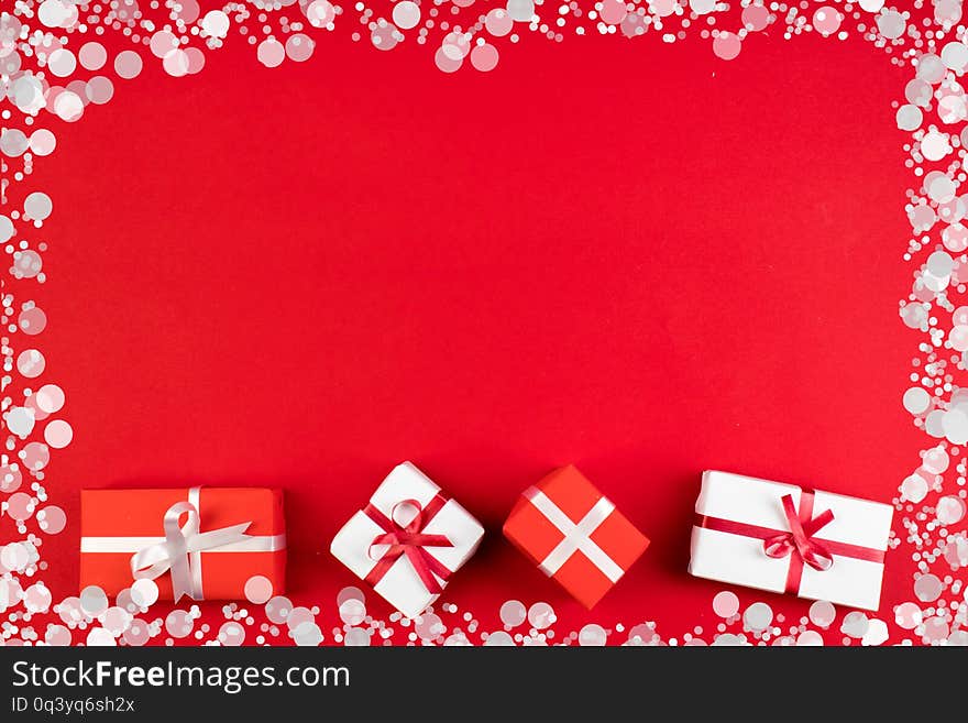 Gift Boxes And Colorful Present For Christmas On Red Background. Top View With Copy Space.