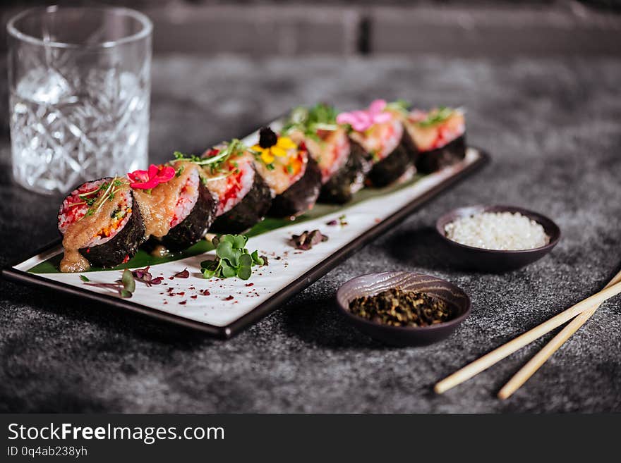 Various kinds of tasty sushi served on black stone