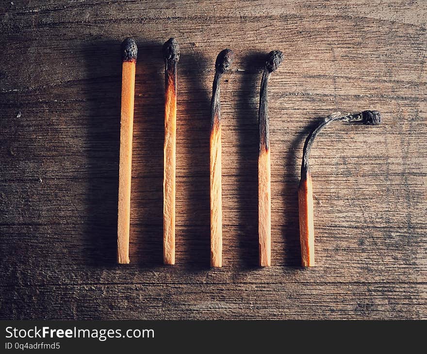 Different stages of match burning. Burnt matches isolated on wooden background. Creative background