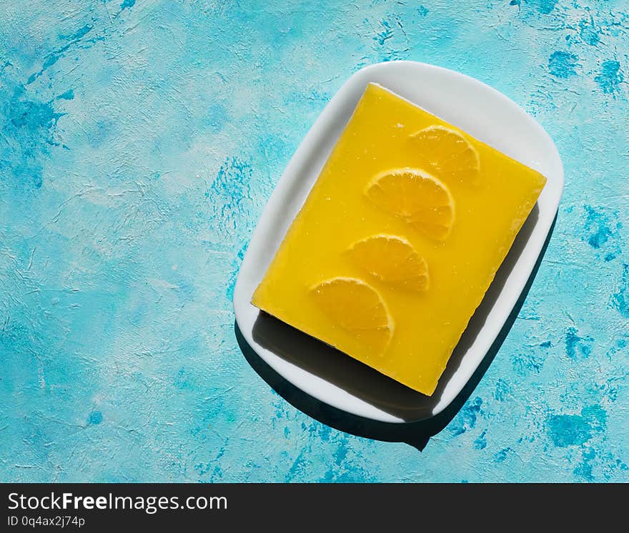 Yellow cheesecake on a bright blue background.