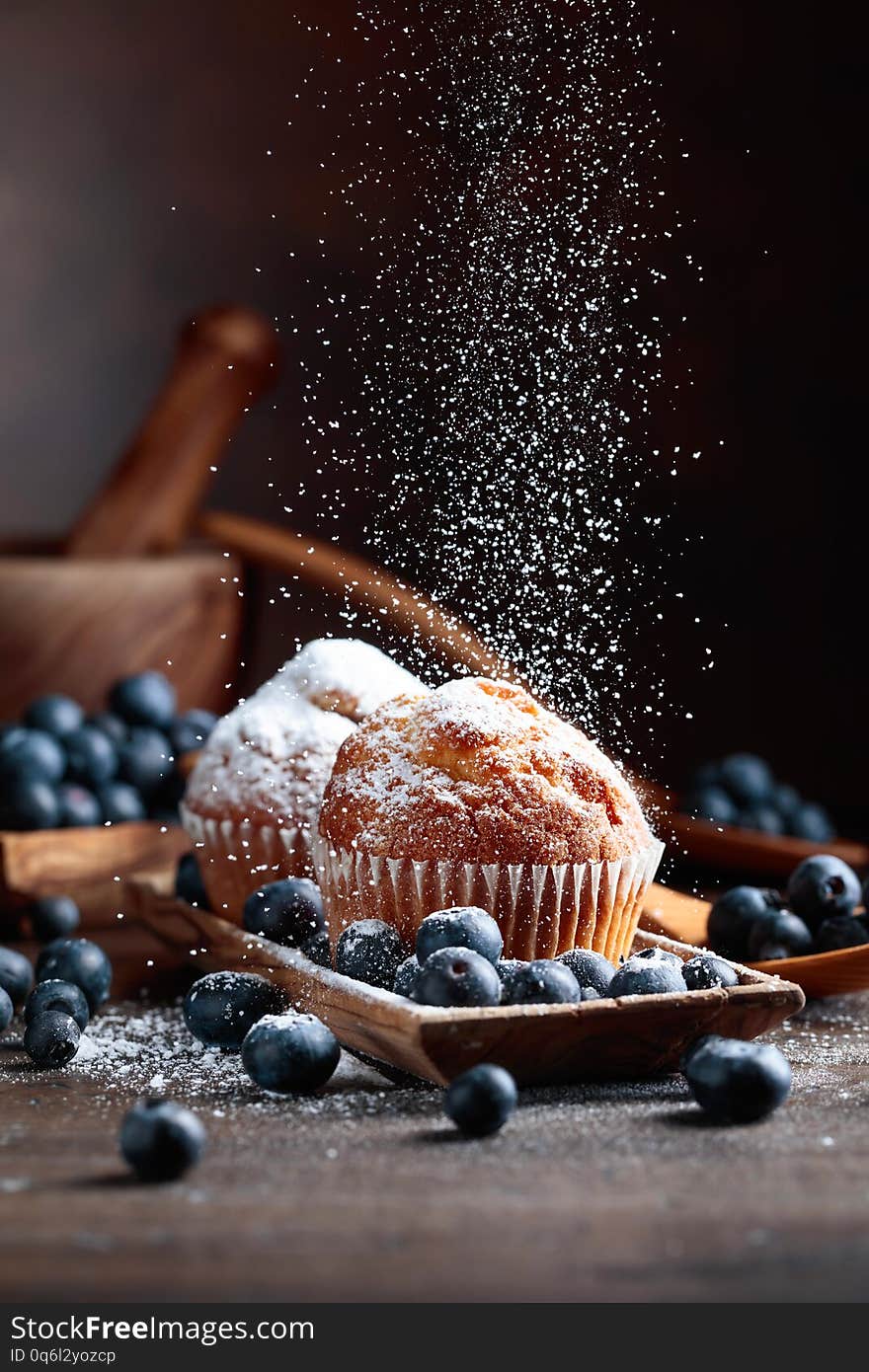 Muffins and blueberries sprinkled with powdered sugar