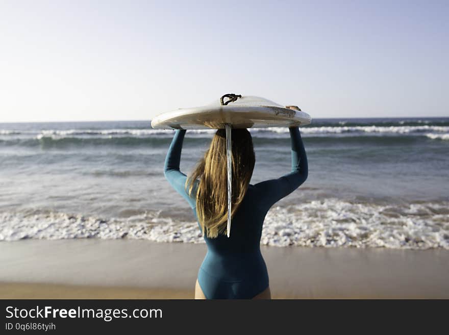 Pretty Surf girl with a longboard on the beach