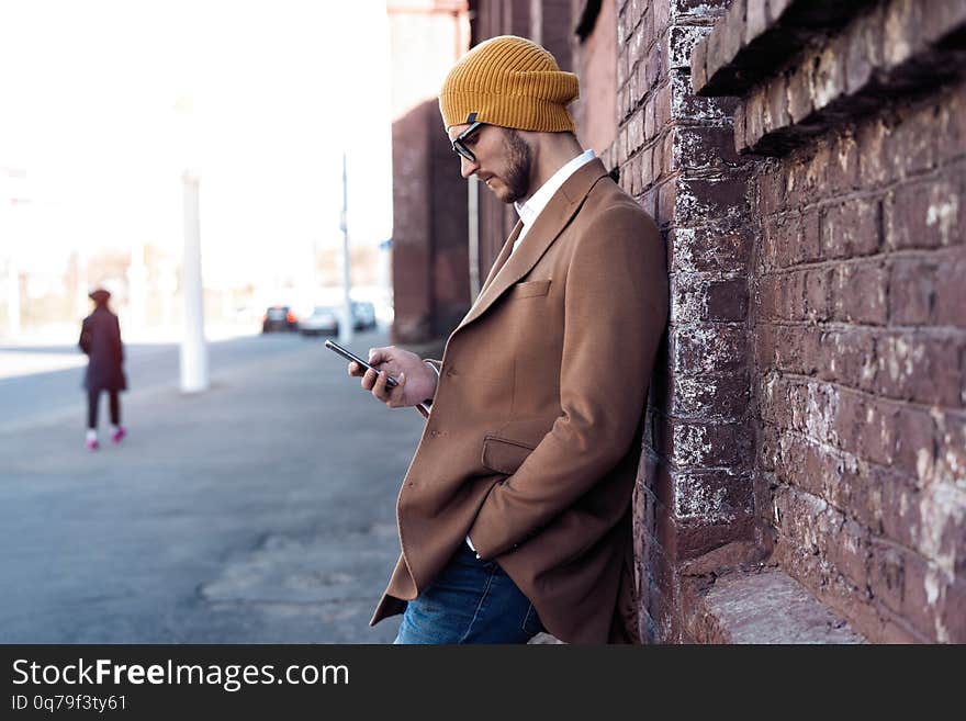 Handsome hipster modern man using smart phone in the city.