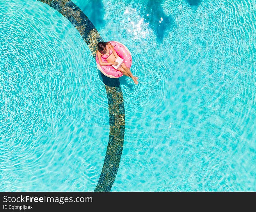 Girl In The Inflatable Circle In The Pool With A Laptop, The Concept Of Freelancing And Recreation.