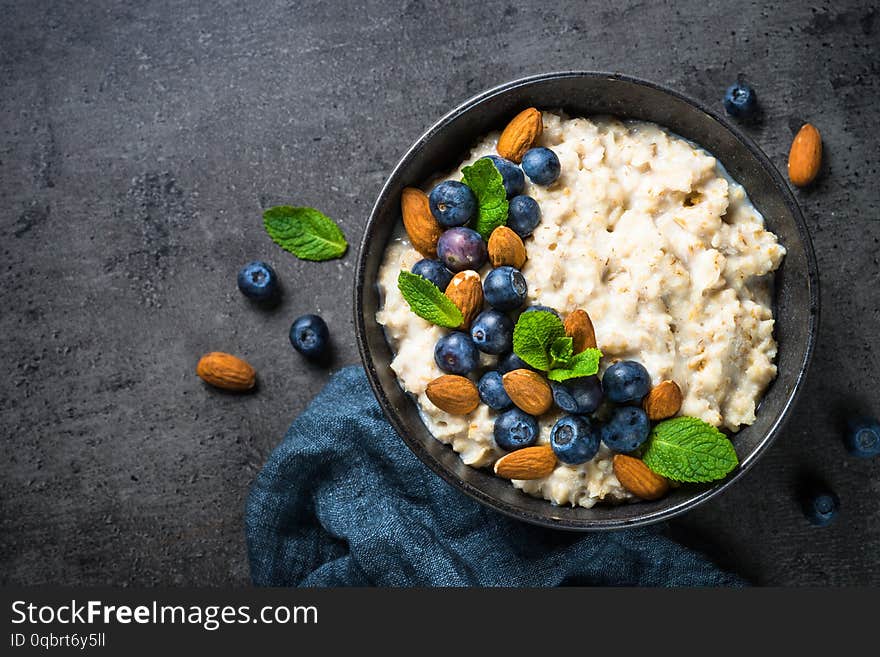 Oatmeal porridge with fresh berries and nuts top view.