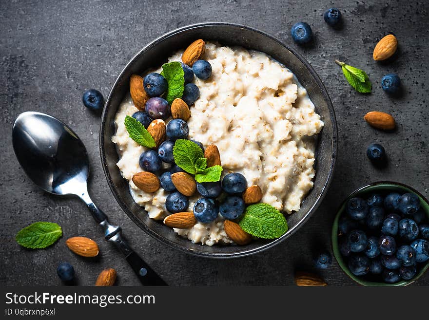 Oatmeal porridge with fresh berries and nuts top view.