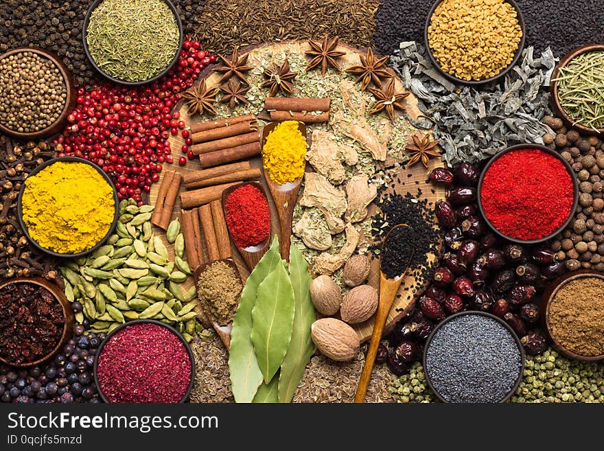 Colorful spices and herbs background. Large set seasonings scattered on table. Colorful spices and herbs background. Large set seasonings scattered on table