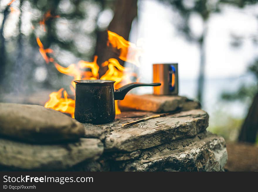 Making coffee in the fireplace when camping or hiking in the nature. Coffee in cezve. Making coffee in the fireplace when camping or hiking in the nature. Coffee in cezve