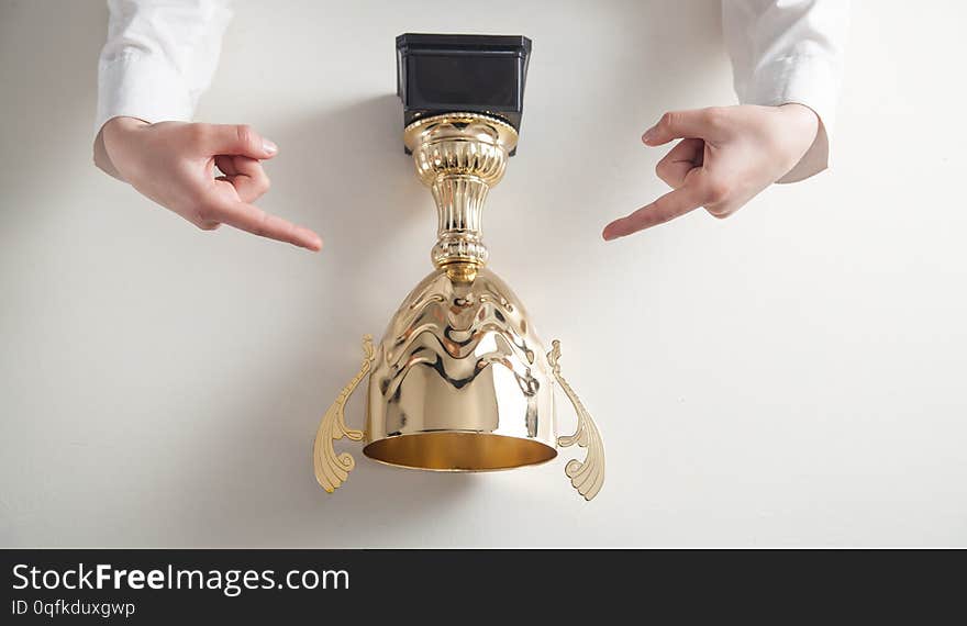 Hands holding golden trophy on white desk. Business, Success