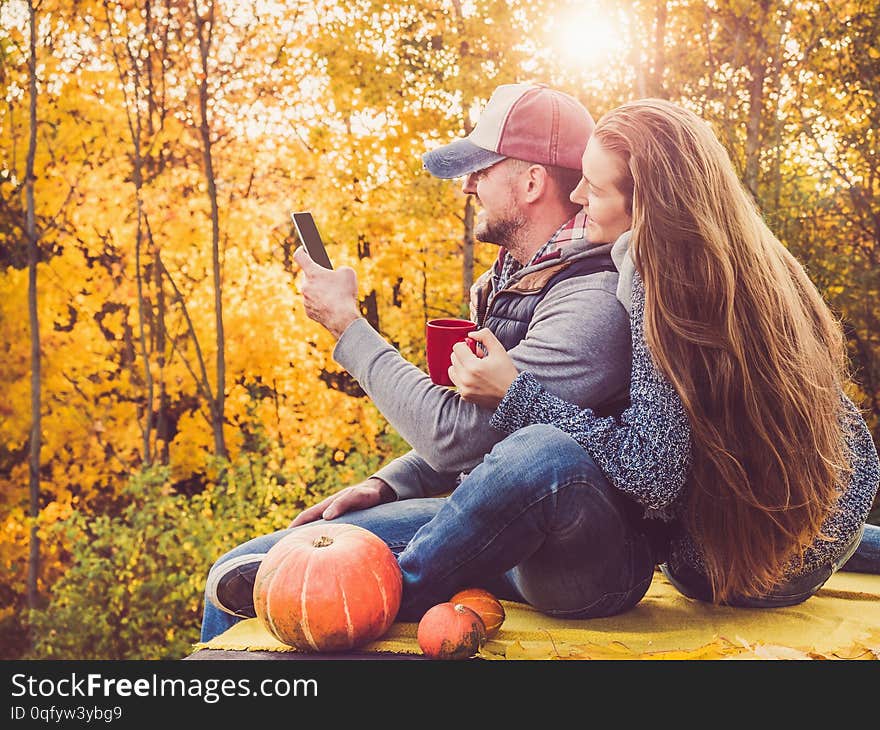 Handsome man and stylish woman holding a phone