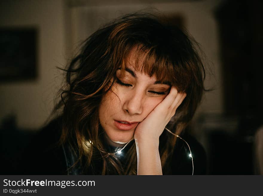 Portrait of bored young woman with led lights with eyes closed