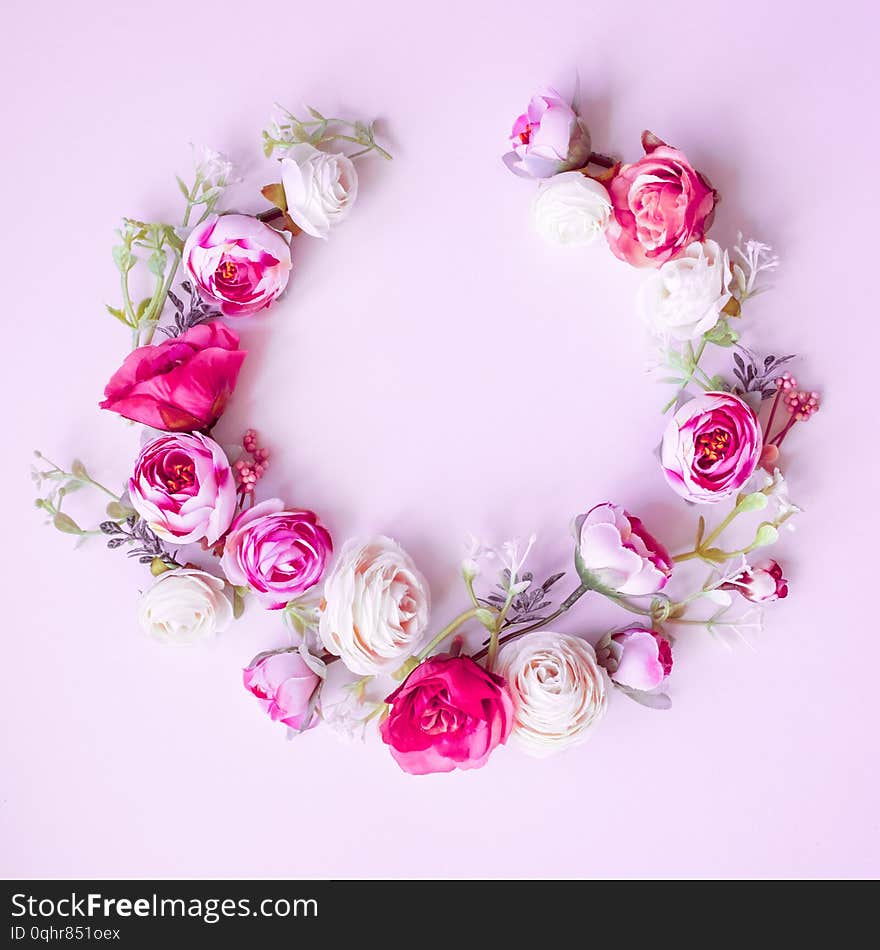 Spring wreath made of colorful flowers on pink  background, place for text, holiday concept. Flat lay. Spring wreath made of colorful flowers on pink  background, place for text, holiday concept. Flat lay.