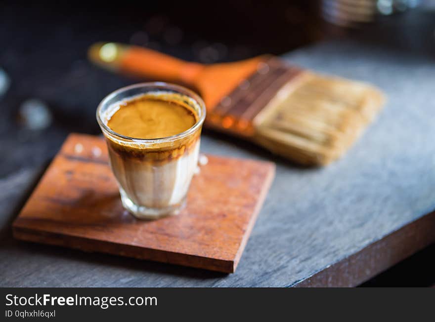 Hot latte coffee in glass on wooden table at coffee shop.