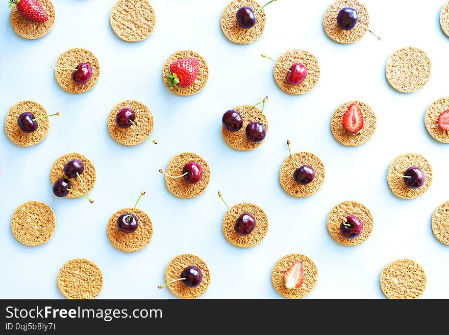 Seamless summer pattern, flat lay with repeating biscuits from cookies and strawberries and cherries. Seamless summer pattern, flat lay with repeating biscuits from cookies and strawberries and cherries