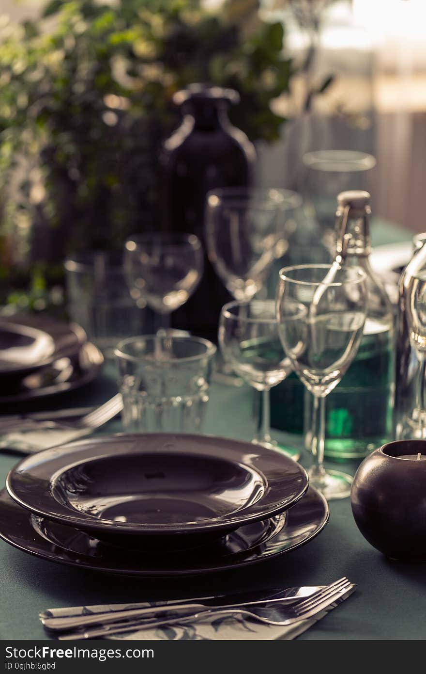 Closeup of black plate on dining room table covered with green tablecloth