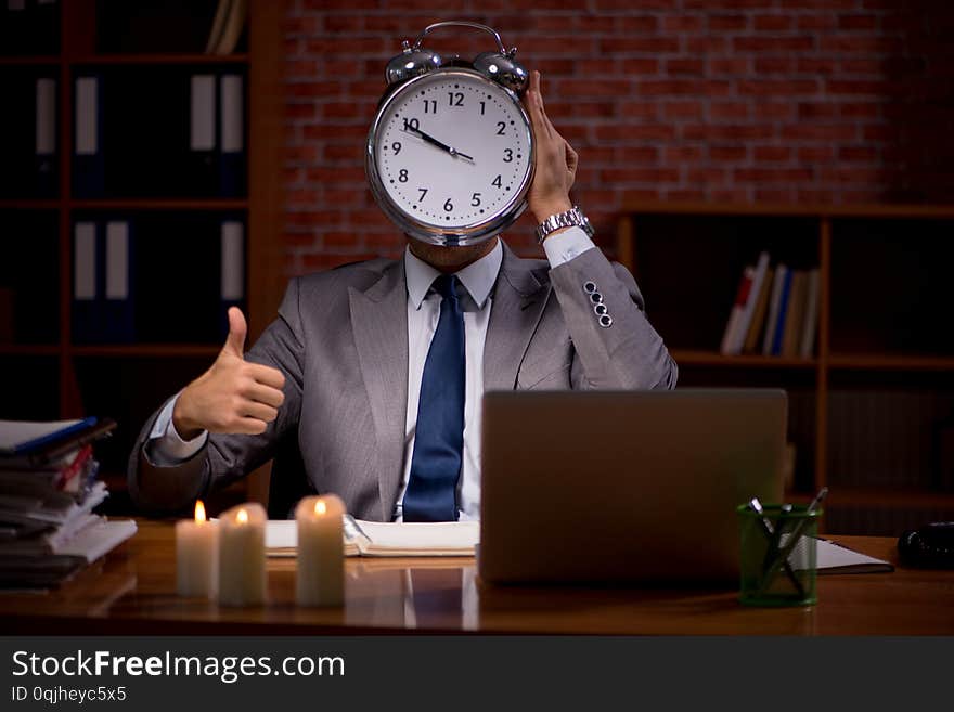 Businessman working late in office with candle light