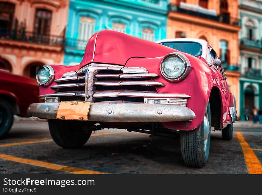 Old car painted hot pink and colorful buildings in Havana. America, american, ancient, antique, architecture, attraction, auto, automobile, beautiful, caribbean, city, classic, cuba, cuban, destination, famous, habana, historic, history, holiday, icon, landmark, latin, oldtimer, retro, road, street, taxi, tourism, tourist, touristic, transport, transportation, travel, tropical, urban, vacation, vehicle, vintage, old-fashioned, heritage