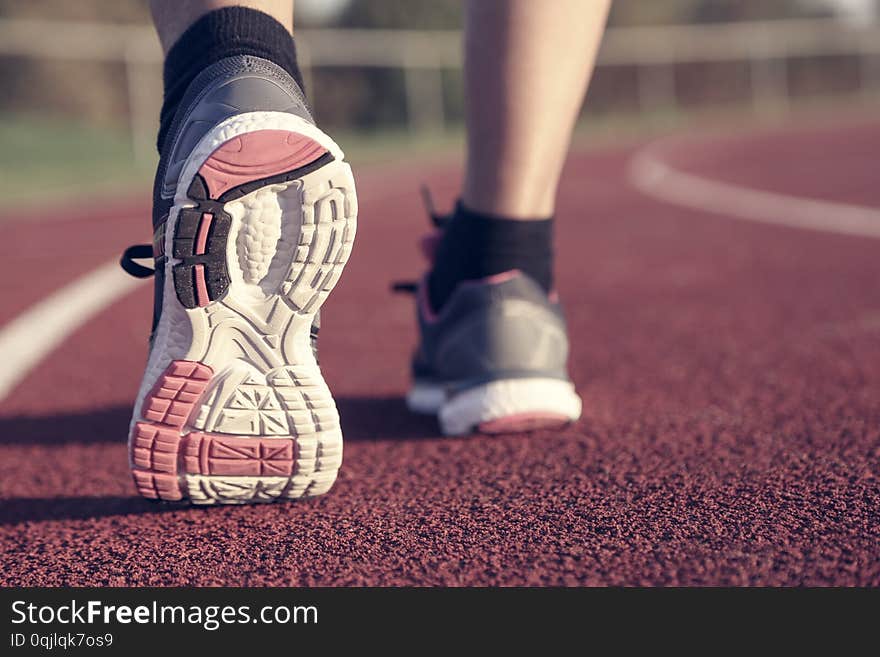 Woman running on athletic track at afternoon