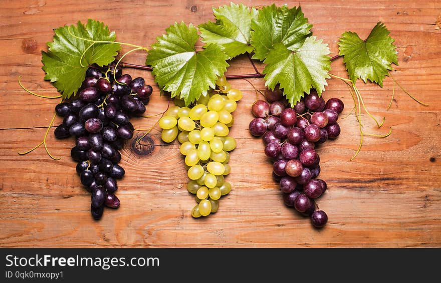 Closeup of set screw with different types of grapes on wooden board. Closeup of set screw with different types of grapes on wooden board