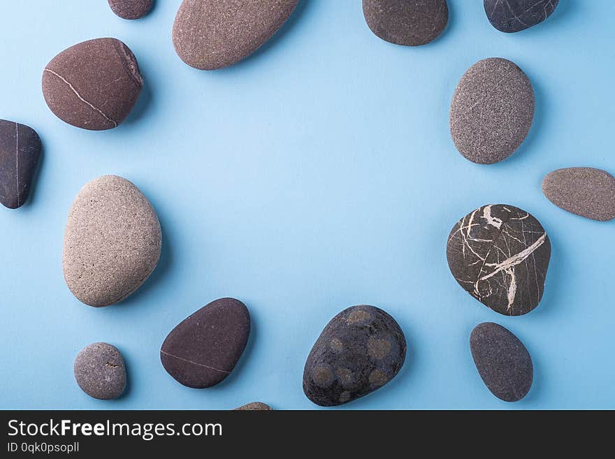 Copy space circle of pebbles summer background top view on blue background bright colors