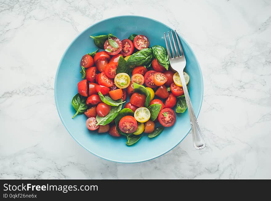 Fresh bright tomato salad from red and yellow tomatoes cherry with basil, olive oil and balsamic vinegar white marble background. Vegetarian and vegan food. Concept for a tasty and healthy meal. Top view. Copy space. Fresh bright tomato salad from red and yellow tomatoes cherry with basil, olive oil and balsamic vinegar white marble background. Vegetarian and vegan food. Concept for a tasty and healthy meal. Top view. Copy space