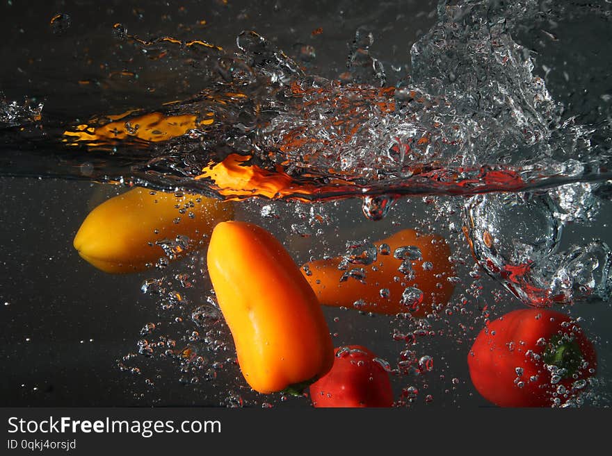 Peppers diving into water splashing