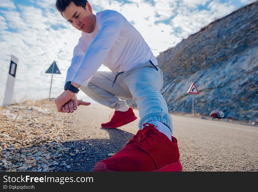 Bodybuilder Performing His Stretching Routine In The Morning On An Empty Road