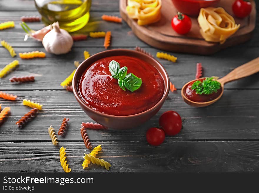 Bowl With Tasty Tomato Sauce On Wooden Table