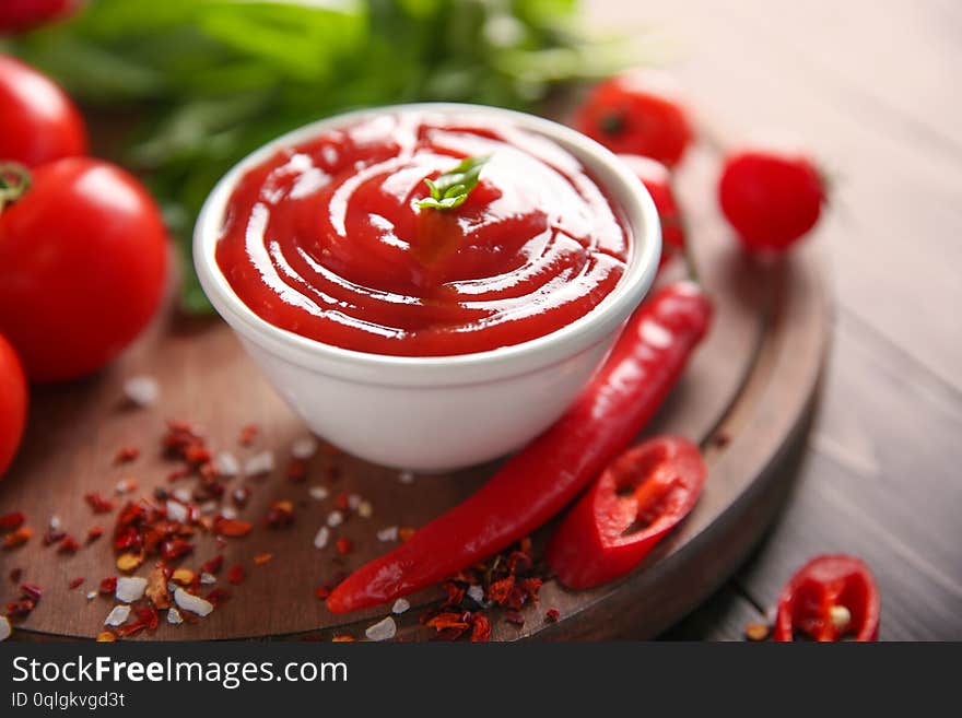 Bowl with red sauce and vegetables on table